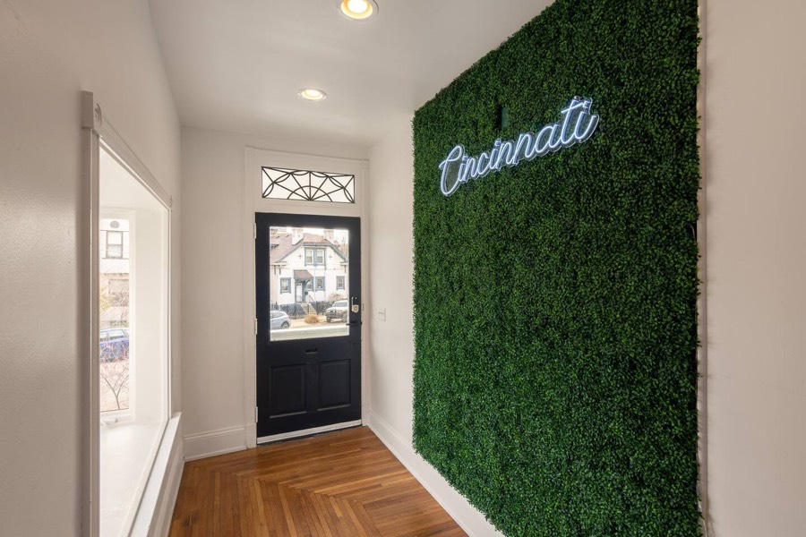 The entry hall, with a boxwood wall and a script Cincinnati sign.