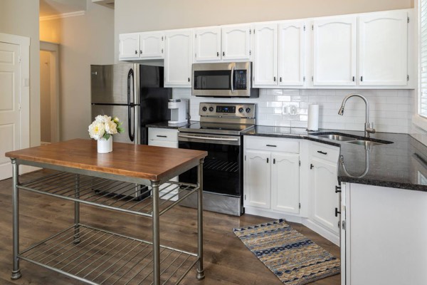 Kitchen with white cabinets in Victorian Estate's first-floor apartment